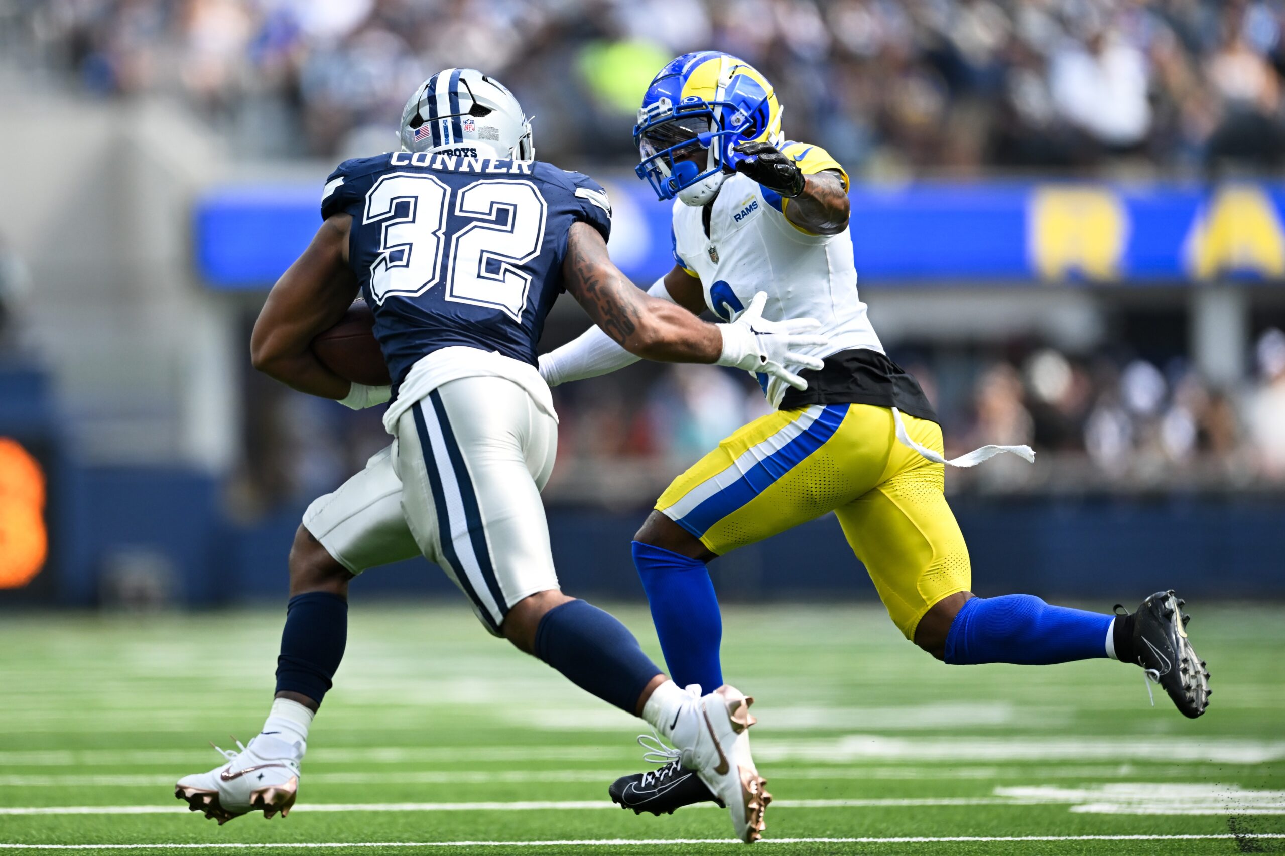 Aug 11, 2024; Inglewood, California, USA; Dallas Cowboys running back Snoop Conner (32) runs the ball against Los Angeles Rams cornerback Tre Tomlinson (6) during the third quarter at SoFi Stadium. Mandatory Credit: Jonathan Hui-Imagn Images