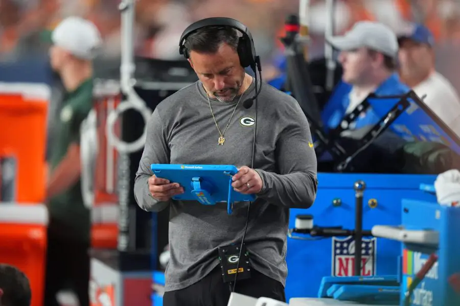 Aug 18, 2024; Denver, Colorado, USA; Green Bay Packers linebackers coach Anthony Campanile looks at a tablet in the second half against the Denver Broncos at Empower Field at Mile High. Mandatory Credit: Ron Chenoy-Imagn Images