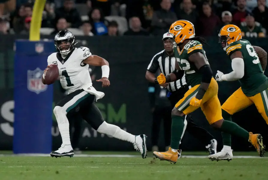 Sep 6, 2024; Sao Paulo, BRA; Philadelphia Eagles quarterback Jalen Hurts (1) scrambles against Green Bay Packers defensive end Rashan Gary (52) during the first half at Neo Quimica Arena. Mandatory Credit: Kirby Lee-Imagn Images