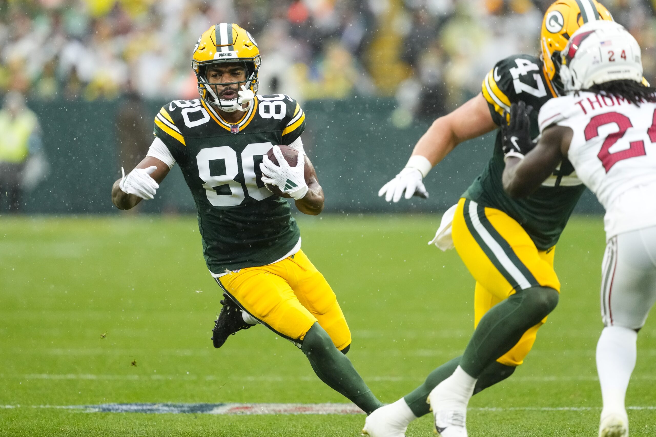 Oct 13, 2024; Green Bay, Wisconsin, USA; Green Bay Packers wide receiver Bo Melton (80) rushes with the football during the first quarter against the Arizona Cardinals at Lambeau Field. Mandatory Credit: Jeff Hanisch-Imagn Images