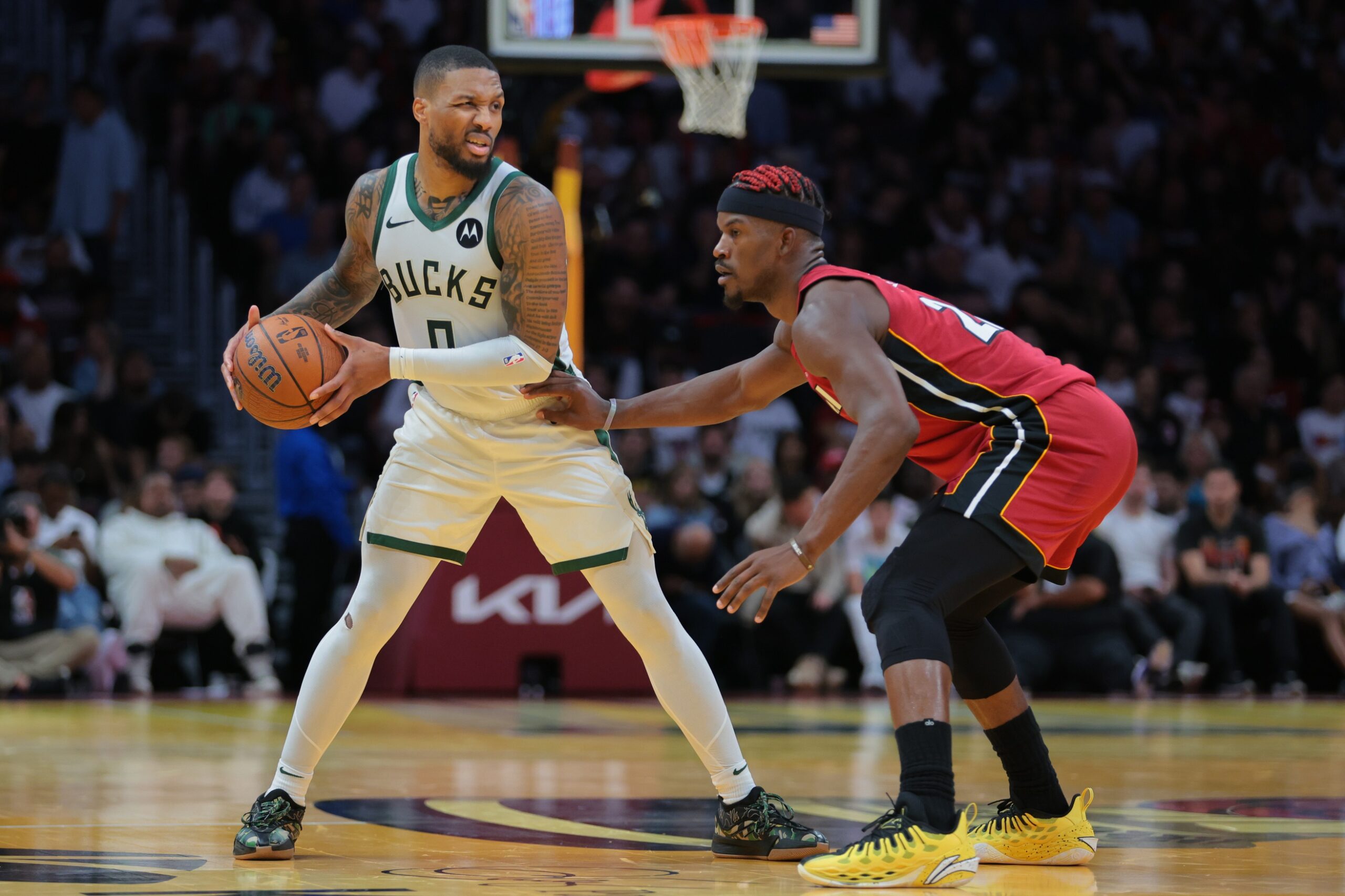 Nov 26, 2024; Miami, Florida, USA; Milwaukee Bucks guard Damian Lillard (0) protects the basketball from Miami Heat forward Jimmy Butler (22) during the third quarter at Kaseya Center. Mandatory Credit: Sam Navarro-Imagn Images