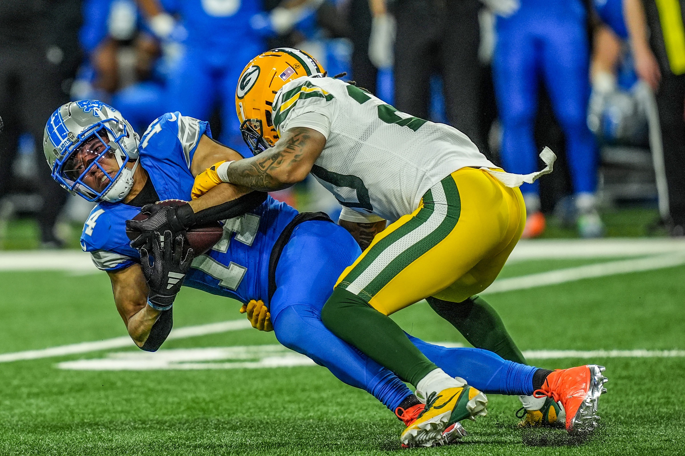 Detroit Lions wide receiver Amon-Ra St. Brown (14) makes a catch, while being covered by Green Bay Packers safety Javon Bullard (20), during the Thursday Night Football game at Ford Field in Detroit on Thursday, Dec. 5, 2024. © Kimberly P. Mitchell / USA TODAY NETWORK via Imagn Images