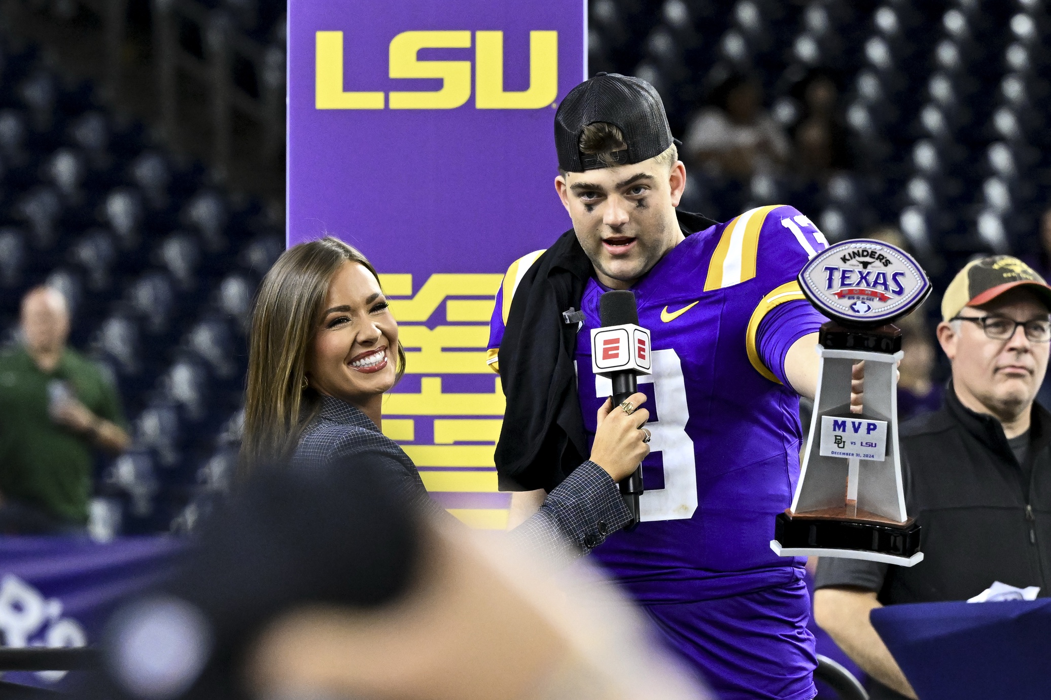 Dec 31, 2024; Houston, TX, USA; LSU Tigers quarterback Garrett Nussmeier (13) holds up the MVP trophy during a post game interview of the game against the Baylor Bears at NRG Stadium. The Tigers defeat the Bears 44-31. Mandatory Credit: Maria Lysaker-Imagn Images Badgers