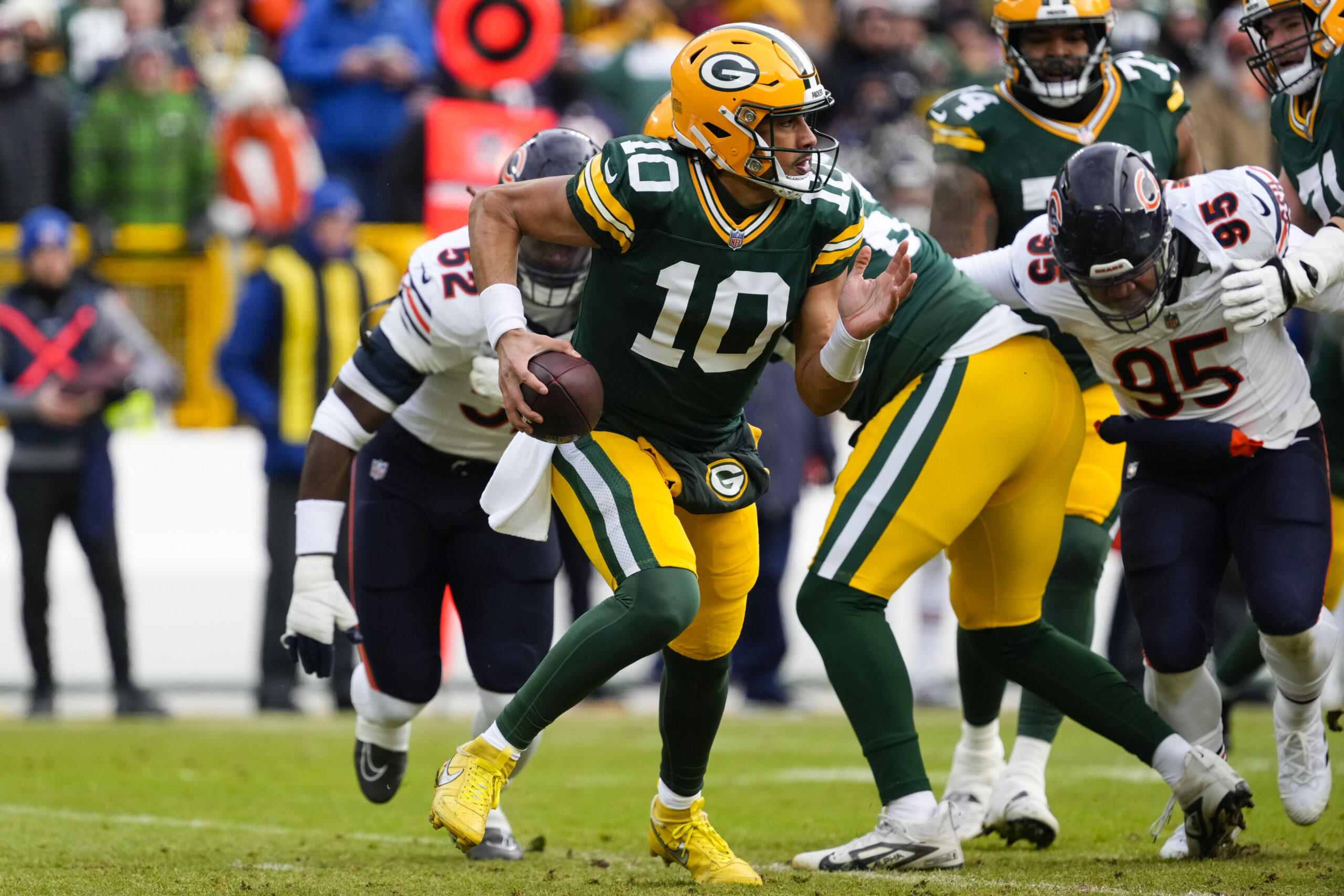 Jan 5, 2025; Green Bay, Wisconsin, USA; Green Bay Packers quarterback Jordan Love (10) scrambles to avoid pressure during the first quarter against the Chicago Bears at Lambeau Field. Mandatory Credit: Jeff Hanisch-Imagn Images