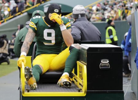 Green Bay Packers wide receiver Christian Watson (9) leaves the field on a cart