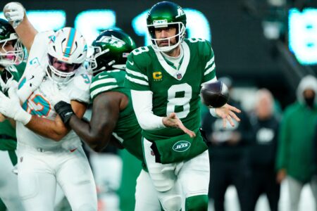 New York Jets quarterback Aaron Rodgers (8) toses the ball to New York Jets wide receiver Davante Adams (17, not shown) as other teammates provide blocking, Sunday January 5, 2025, in East Rutherford. © Kevin R. Wexler-NorthJersey.com / USA TODAY NETWORK via Imagn Images