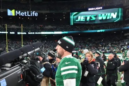 Jan 5, 2025; East Rutherford, New Jersey, USA; New York Jets quarterback Aaron Rodgers (8) walks on the field after the Jets win over the Miami Dolphins at MetLife Stadium. Mandatory Credit: Ed Mulholland-Imagn Images