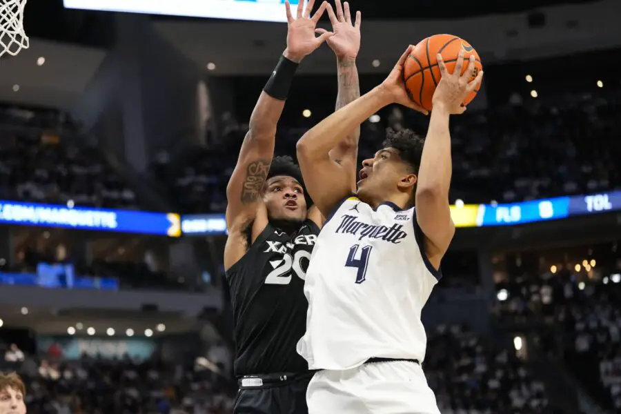 Jan 18, 2025; Milwaukee, Wisconsin, USA; Marquette Golden Eagles guard Stevie Mitchell (4) shoots against Xavier Musketeers guard Dayvion McKnight (20) during the second half at Fiserv Forum. Mandatory Credit: Jeff Hanisch-Imagn Images