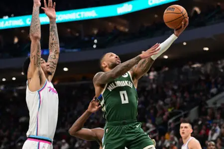 Jan 23, 2025; Milwaukee, Wisconsin, USA; Milwaukee Bucks guard Damian Lillard (0) takes a shot against Miami Heat center Kel'el Ware (7) in the third quarter at Fiserv Forum. Mandatory Credit: Benny Sieu-Imagn Images