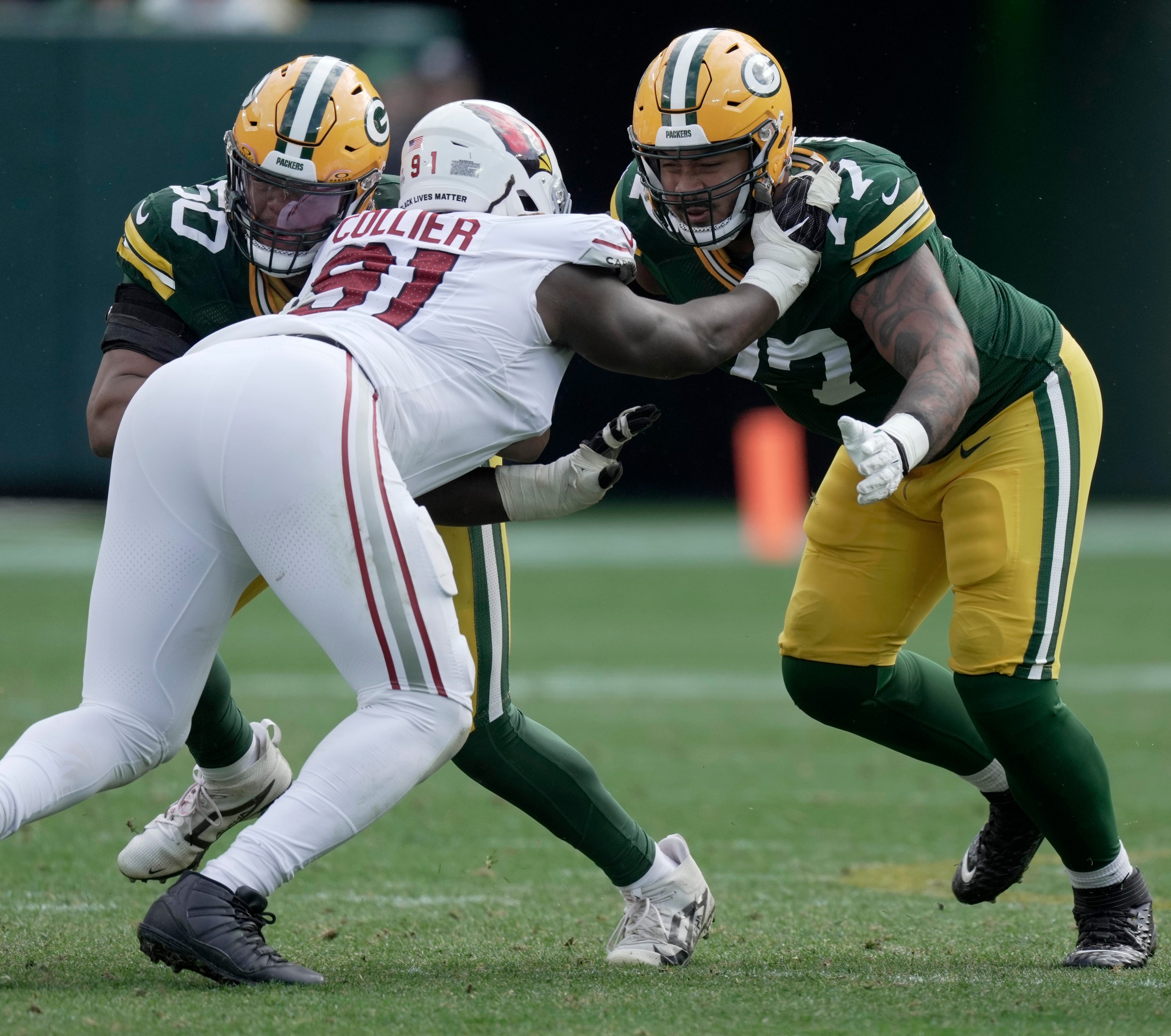 Green Bay Packers guard Zach Tom (50) and offensive tackle Jordan Morgan (77) team p to blocks Arizona Cardinals defensive end L.J. Collier (91) during the third quarter of their game Sunday, October 13, 2024 at Lambeau Field in Green Bay, Wisconsin. The Green Bay Packers beat the Arizona Cardinals 34-13.© Mark Hoffman/Milwaukee Journal Sentinel / USA TODAY NETWORK via Imagn Images