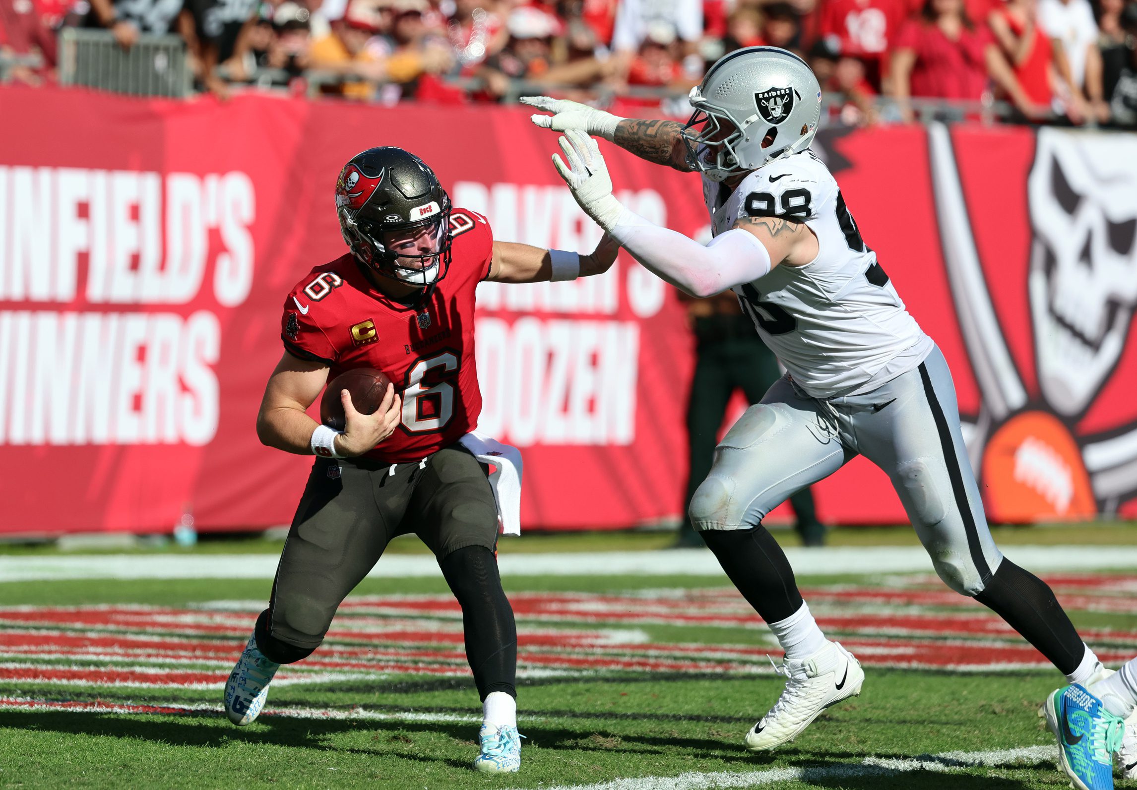 Dec 8, 2024; Tampa, Florida, USA; Tampa Bay Buccaneers quarterback Baker Mayfield (6) gets pressured by Las Vegas Raiders defensive end Maxx Crosby (98) during the second quarter at Raymond James Stadium. Mandatory Credit: Kim Klement Neitzel-Imagn Images Packers