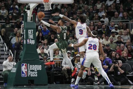 Feb 9, 2025; Milwaukee, Wisconsin, USA; Milwaukee Bucks guard Damian Lillard (0) shoots against Philadelphia 76ers forward Kelly Oubre Jr. (9) during the second quarter at Fiserv Forum. Mandatory Credit: Jeff Hanisch-Imagn Images