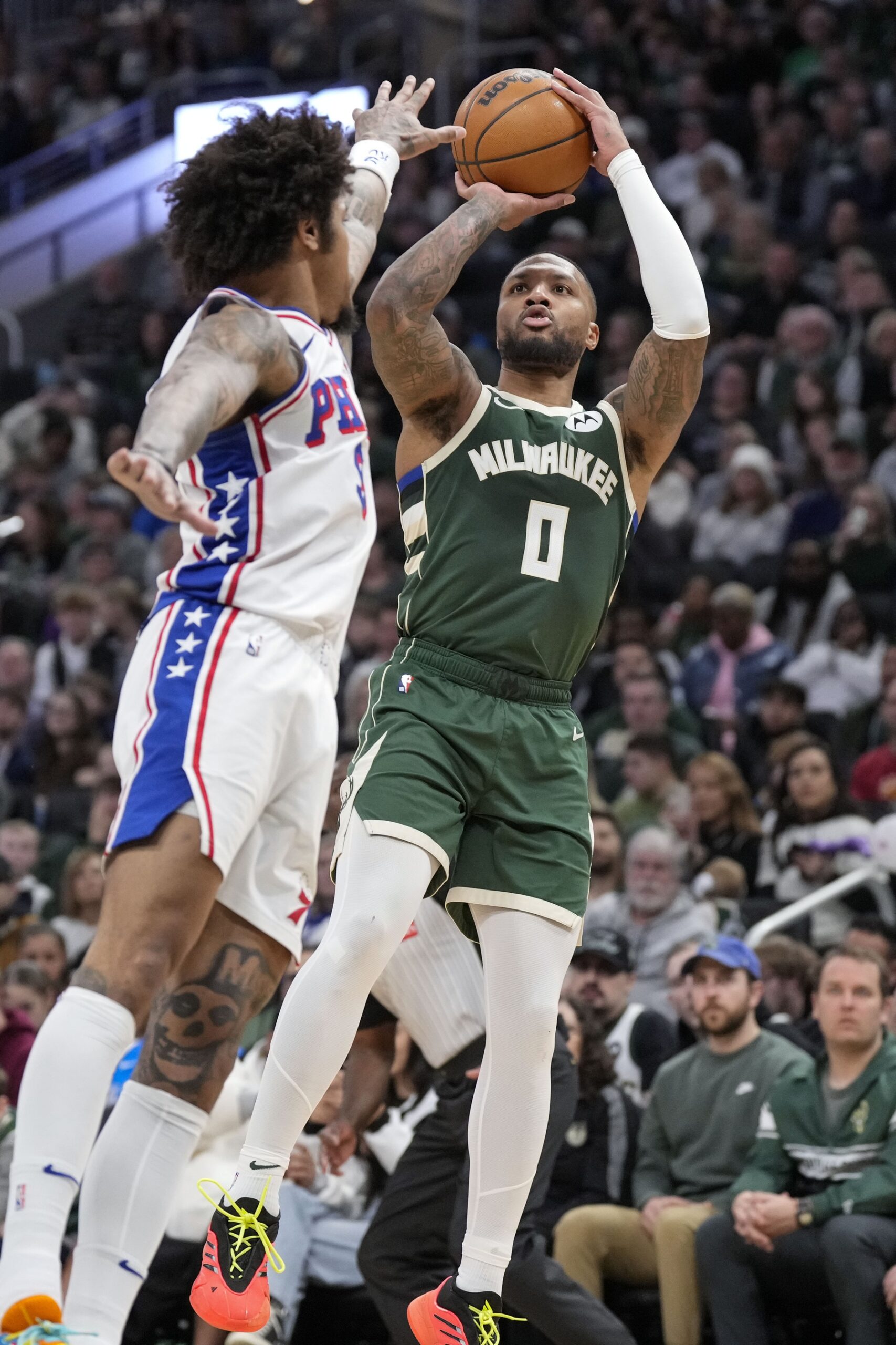 Feb 9, 2025; Milwaukee, Wisconsin, USA; Milwaukee Bucks guard Damian Lillard (0) shoots against Philadelphia 76ers forward Paul George (8) during the fourth quarter at Fiserv Forum. Mandatory Credit: Jeff Hanisch-Imagn Images