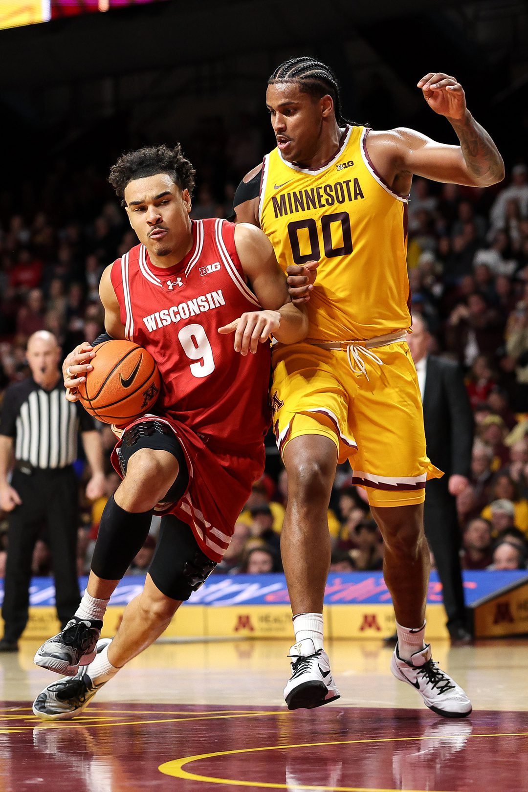 Mar 5, 2025; Minneapolis, Minnesota, USA; Wisconsin Badgers guard John Tonje (9) drives towards the basket as Minnesota Golden Gophers forward Frank Mitchell (00) defends during the second half at Williams Arena. Mandatory Credit: Matt Krohn-Imagn Images
