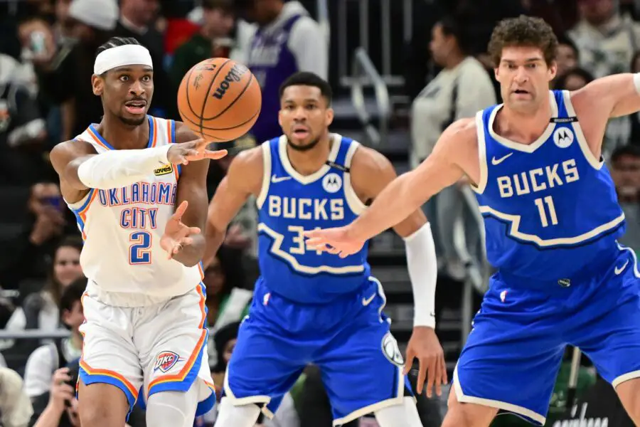 Shai Gilgeous-Alexander (2) passes the ball away from Milwaukee Bucks forward Giannis Antetokounmpo (34) and center Brook Lopez (11)