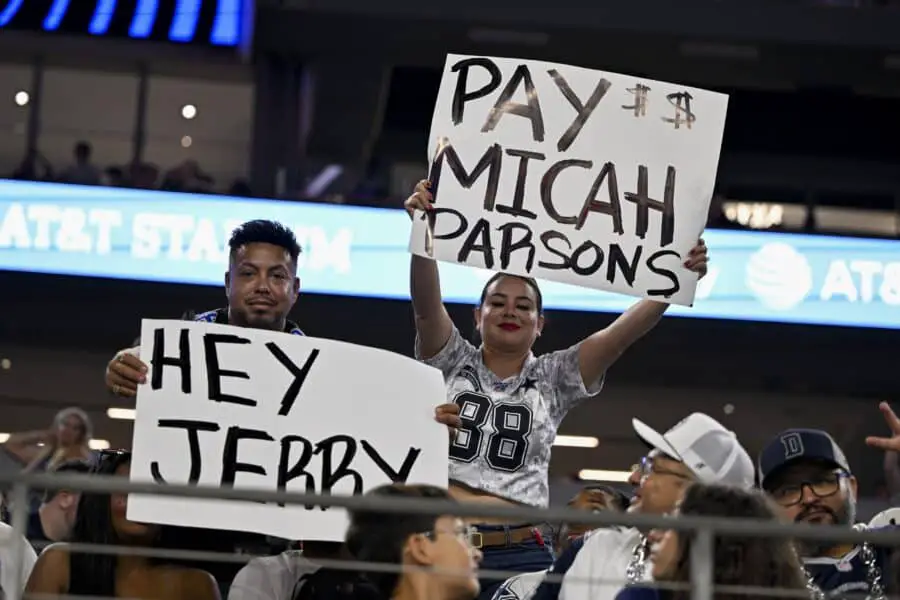 Dallas Cowboys fans hold up signs to owner Jerry Jones, Micah Parsons, Green Bay Packers