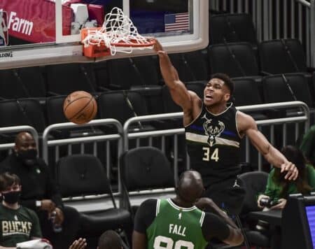 Giannis Antetokounmpo cracks up Tacko Fall with sideline advice at Celebrity All-Star Game Mar 26, 2021; Milwaukee, Wisconsin, USA; Milwaukee Bucks forward Giannis Antetokounmpo (34) dunks a basket against Boston Celtics center Tacko Fall (99) in the second quarter at Fiserv Forum. Mandatory Credit: Benny Sieu-Imagn Images