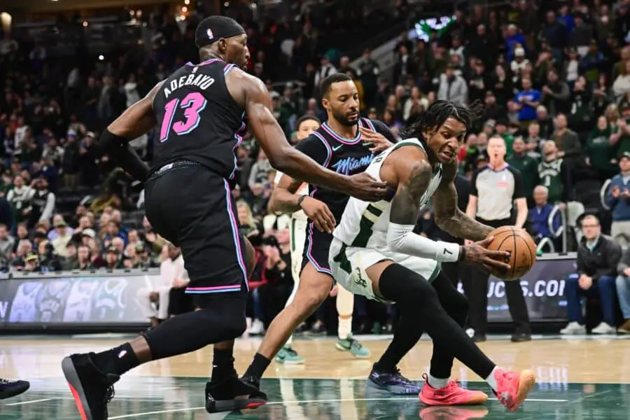 Feb 24, 2026; Milwaukee, Wisconsin, USA; Milwaukee Bucks guard Kevin Porter (7) gets pressure from Miami Heat guard Norman Powell (24) and forward Bam Adebayo (13) in the fourth quarter at Fiserv Forum. Mandatory Credit: Benny Sieu-Imagn Images